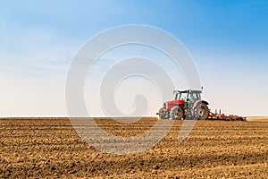 Farmer in tractor preparing land with seedbed cultivator