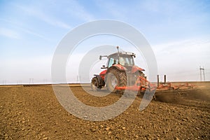 Farmer in tractor preparing land with seedbed cultivator