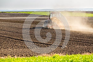 Farmer in tractor preparing land with seedbed cultivator