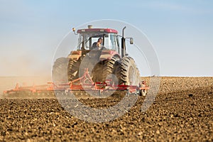 Farmer in tractor preparing land with seedbed cultivator