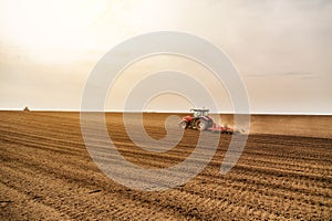 Farmer in tractor preparing land with seedbed cultivator.