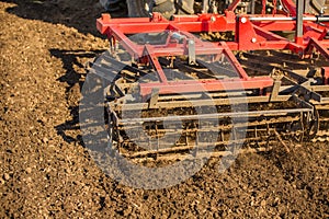 Farmer in tractor preparing land with seedbed cultivator.