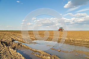 Farmer in tractor preparing land with seedbed cultivator.