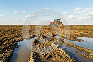 Farmer in tractor preparing land with seedbed cultivator.