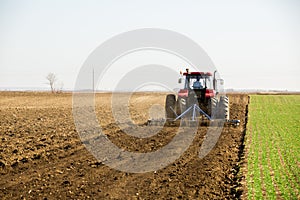 Farmer in tractor preparing land with seedbed cultivator