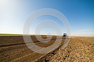 Farmer in tractor preparing land with seedbed cultivator