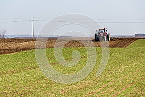 Farmer in tractor preparing land with seedbed cultivator