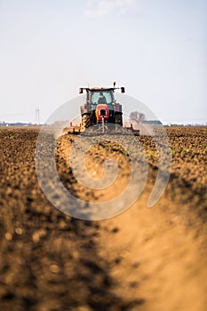 Farmer in tractor preparing land with seedbed cultivator