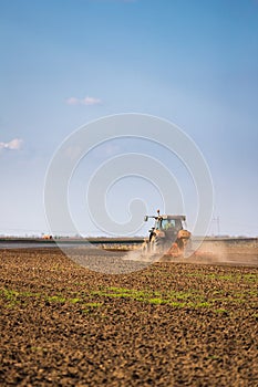 Farmer in tractor preparing land with seedbed cultivator