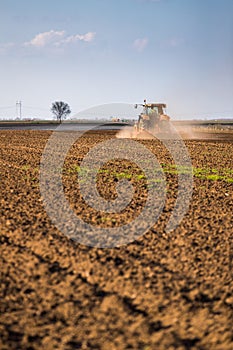 Farmer in tractor preparing land with seedbed cultivator