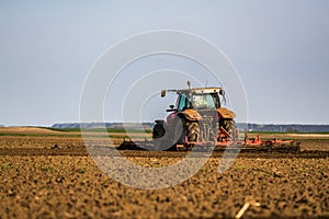 Farmer in tractor preparing land with seedbed cultivator