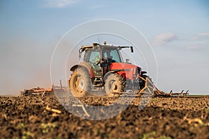 Farmer in tractor preparing land with seedbed cultivator