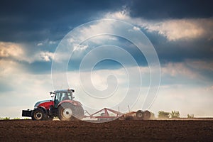 Farmer in tractor preparing land with seedbed cultivator