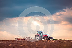 Farmer in tractor preparing land with seedbed cultivator