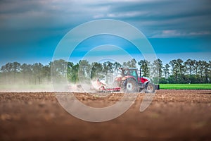 Farmer in tractor preparing land with seedbed cultivator