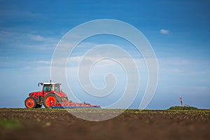 Farmer in tractor preparing land with seedbed cultivator