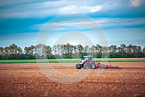 Farmer in tractor preparing land with seedbed cultivator