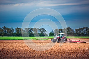 Farmer in tractor preparing land with seedbed cultivator