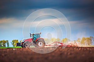 Farmer in tractor preparing land with seedbed cultivator