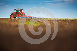 Farmer in tractor preparing land with seedbed cultivator