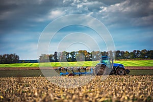 Farmer in tractor preparing land with seedbed cultivator