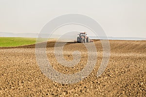 Farmer in tractor preparing land with seedbed cultivator as part of pre seeding activities in early spring season of agricultural