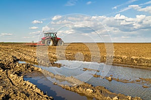 Farmer in tractor preparing land with seedbed cultivator. photo