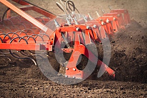 Farmer in tractor preparing land with seedbed cultivator in earl