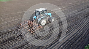 Farmer in tractor preparing land with seedbed cultivator at spring