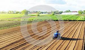 A farmer on a tractor processes a farm field. Cultivating land soil for further planting. Loosening, improving soil quality. Food photo