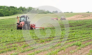 Farmer with tractor seeding soy crops at agricultural field photo