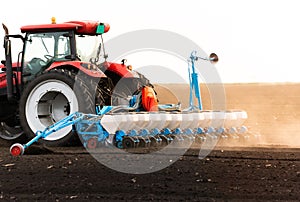 Farmer with tractor seeding photo