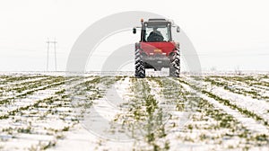 Farmer with tractor seeding - sowing crops at agricultural field