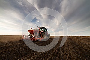 Farmer with tractor seeding photo