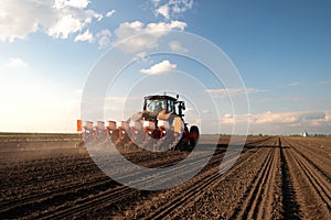 Farmer with tractor seeding in sunset photo
