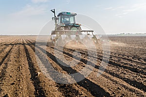 Farmer with tractor seeding - sowing soy crops at agricultural f