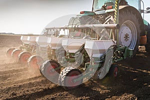 Farmer with tractor seeding - sowing soy crops at agricultural f