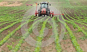 Farmer with tractor seeding soy crops at agricultural field