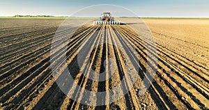 Farmer with tractor seeding soy crops at agricultural field photo