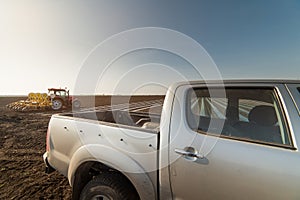 Farmer with tractor seeding - suv offroad vehicle on the field