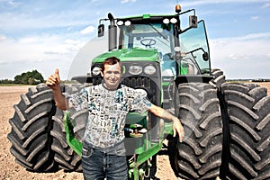 Farmer with tractor showing OK gesture