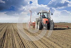 Farmer in tractor sowing crops