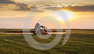 Farmer in tractor spraying crops