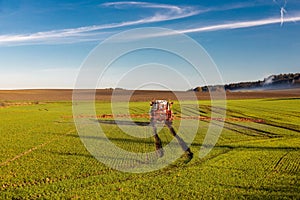 Farmer with tractor spraying herbicide