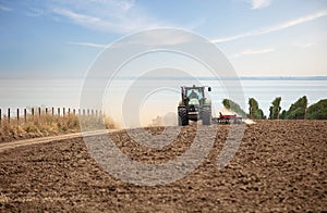 Farmer in tractor working in field on summer day