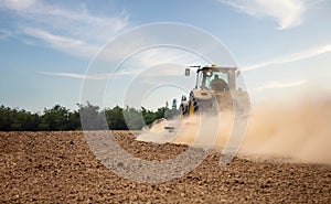 Farmer in tractor working in field on summer day