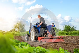 A farmer on a tractor works in the field. Milling soil, crushing and loosening ground. Working as a farmer. Farming. Preparatory