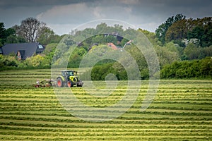 farmer turns the hay in a field with his tractor