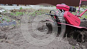 a farmer uses a red-colored technique to cultivate a small plot of land. plows, cultivates the land