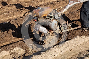 Farmer using motorized cultivator on the field